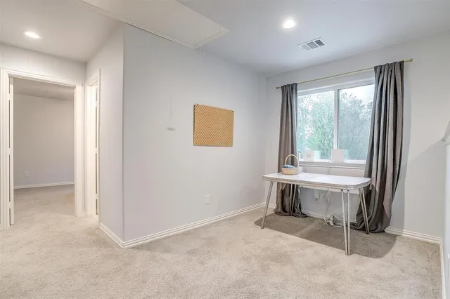 a view of an empty room with a window and furniture