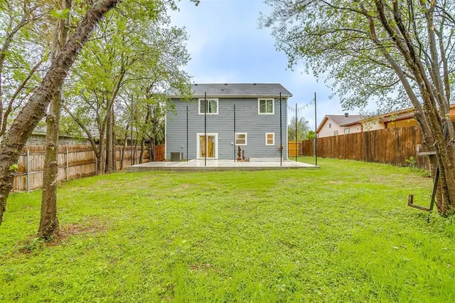 a view of a house with backyard and a tree