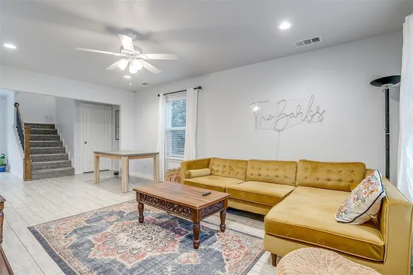 a living room with furniture and a wooden floor