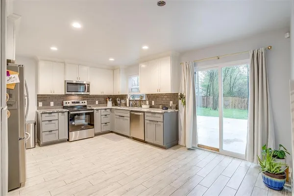 a kitchen with a refrigerator and a stove top oven