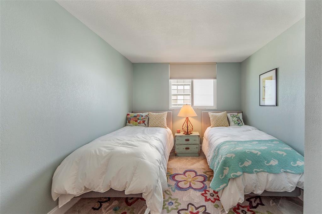 15400 Gulf Boulevard, Unit 505 Madeira Beach, FL 33708 - Photo 20 of 27 a bedroom with two beds and a window