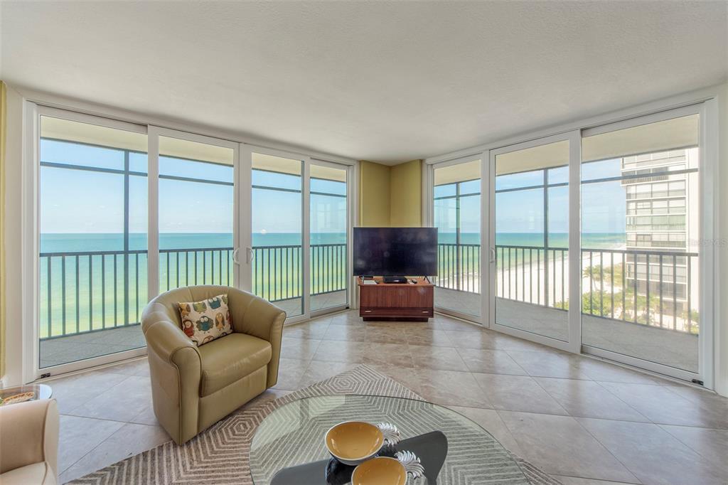 15400 Gulf Boulevard, Unit 505 Madeira Beach, FL 33708 - Photo 2 of 27 a living room with furniture and a floor to ceiling window