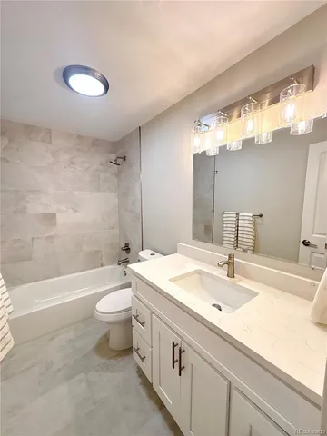 a bathroom with a double vanity sink toilet mirror and bathtub