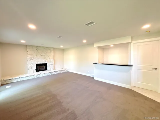 a view of an empty room with a fireplace and a window