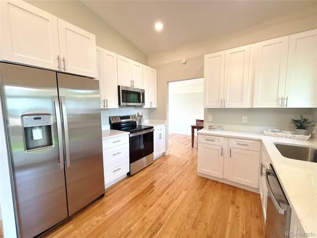 a kitchen with a refrigerator stove top oven and sink