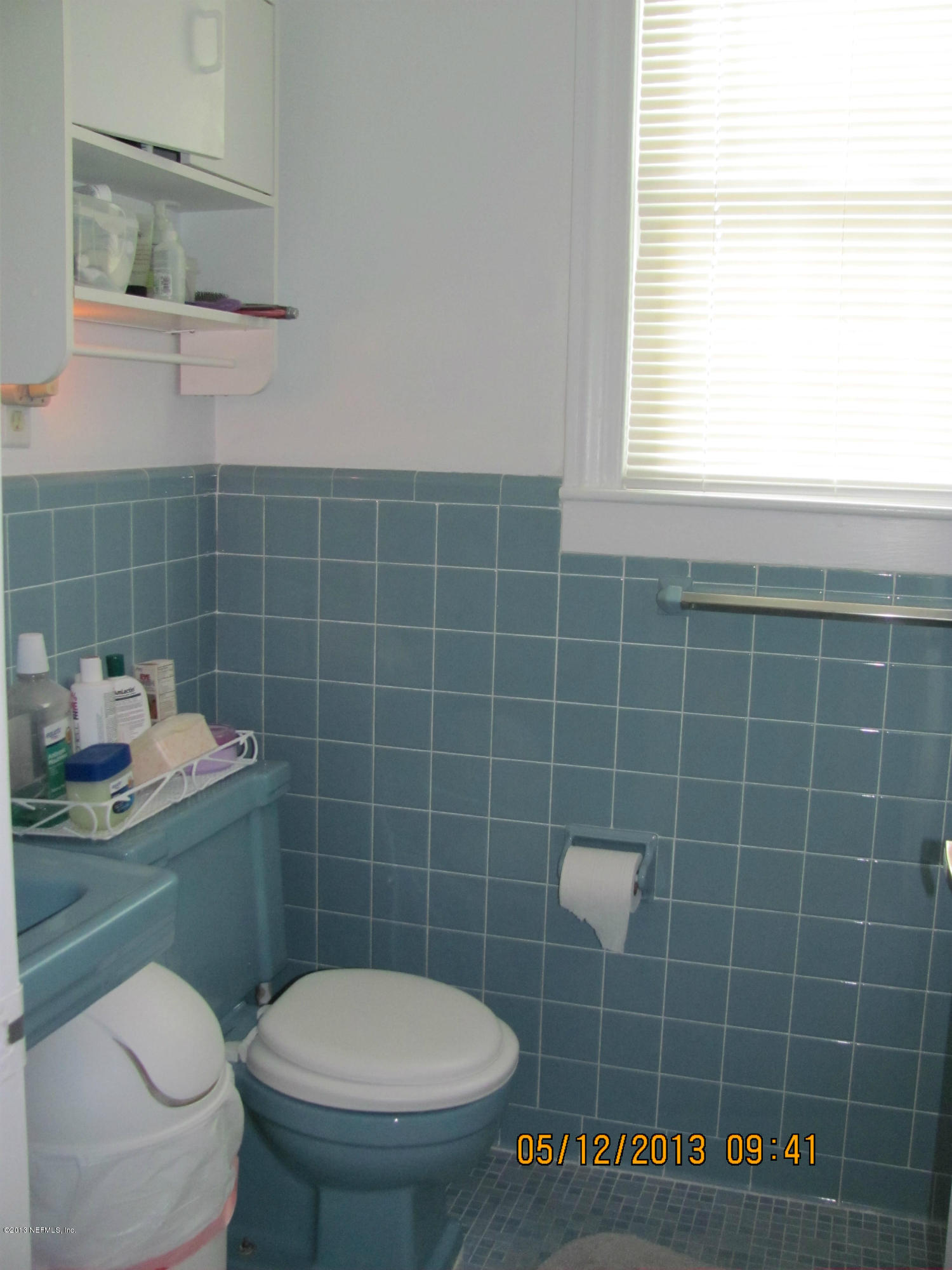 2121 Southampton Road Jacksonville, FL 32207 - Photo 13 of 21 a bathroom with a toilet a sink a mirror and a window