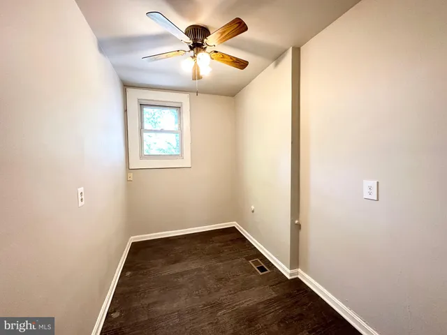 an empty room with a window and a fan