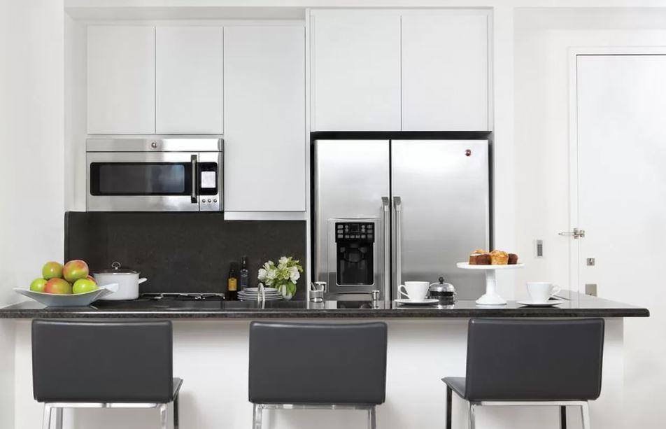 a kitchen with stainless steel appliances a sink table and chairs in it