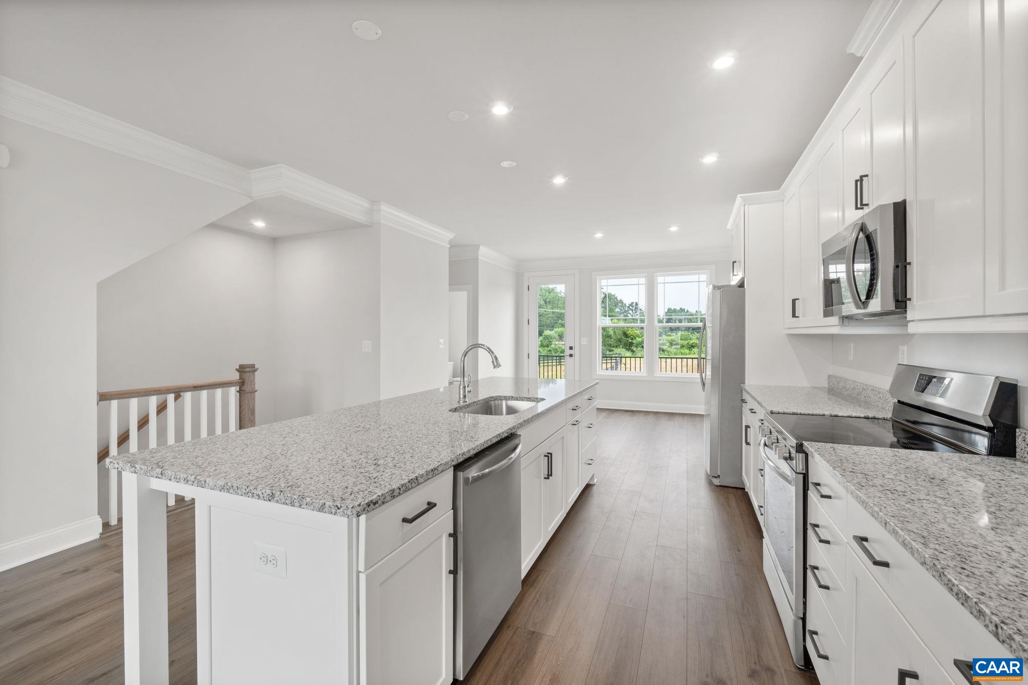 135 Park Ridge Drive Crozet, VA 22932 - Photo 12 of 46 a kitchen with granite countertop a stove a sink a refrigerator and blue cabinets with wooden floor