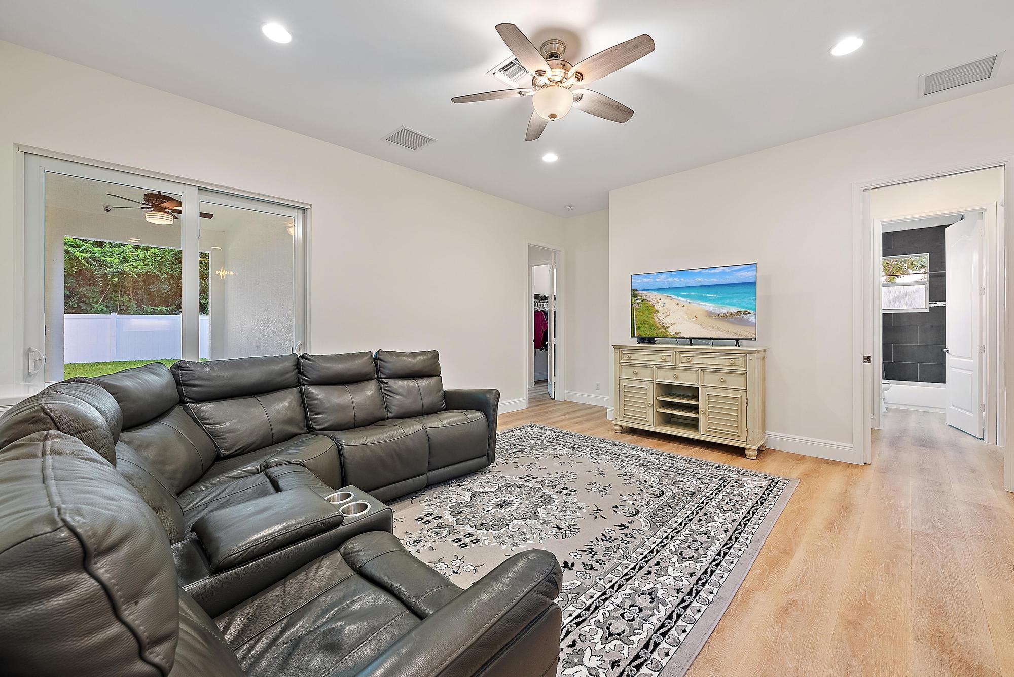 6762 2nd Street Jupiter, FL 33458 - Photo 12 of 27 a living room with furniture a fireplace and a flat screen tv
