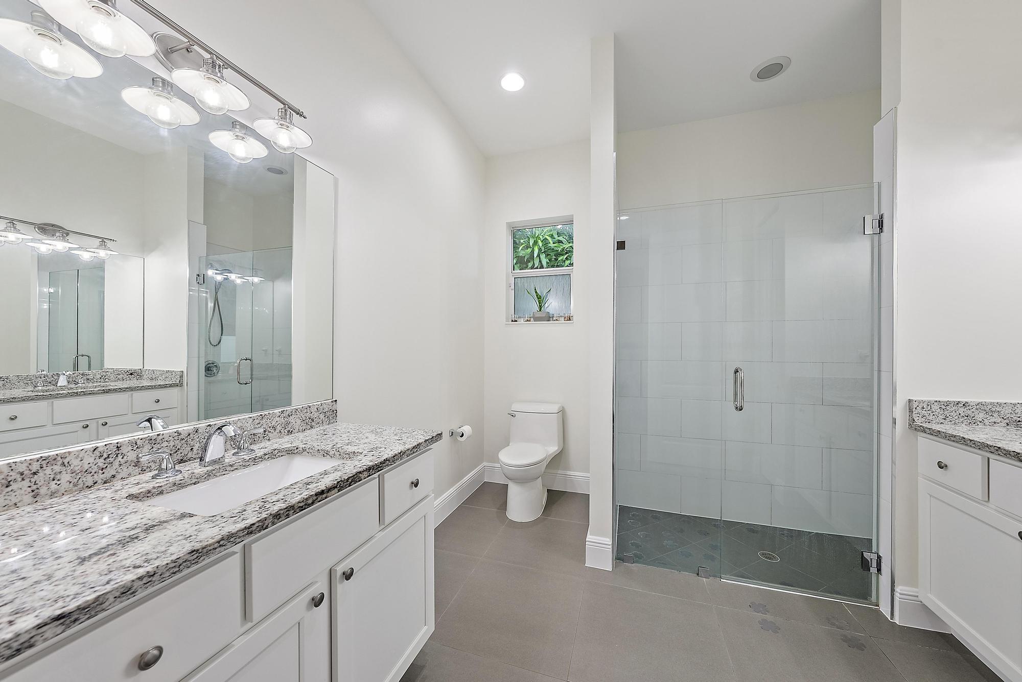 6762 2nd Street Jupiter, FL 33458 - Photo 16 of 27 a bathroom with a granite countertop sink a toilet and a mirror