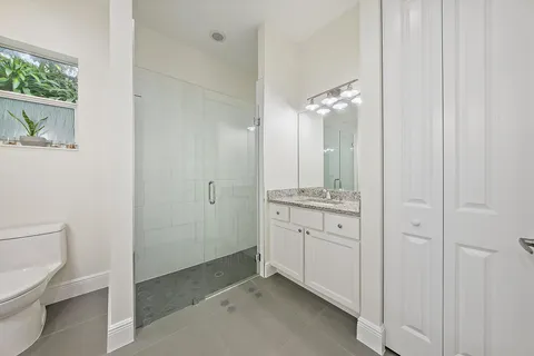 a spacious bathroom with a granite countertop sink and a mirror