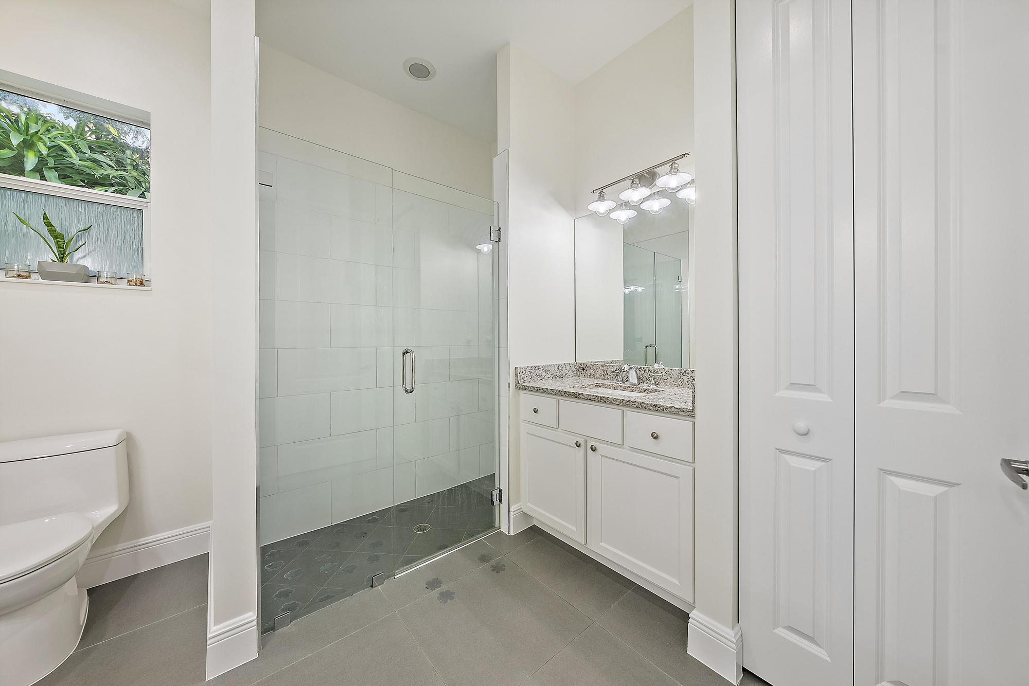 6762 2nd Street Jupiter, FL 33458 - Photo 17 of 27 a spacious bathroom with a granite countertop sink and a mirror