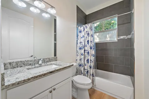 a bathroom with a granite countertop sink toilet and shower