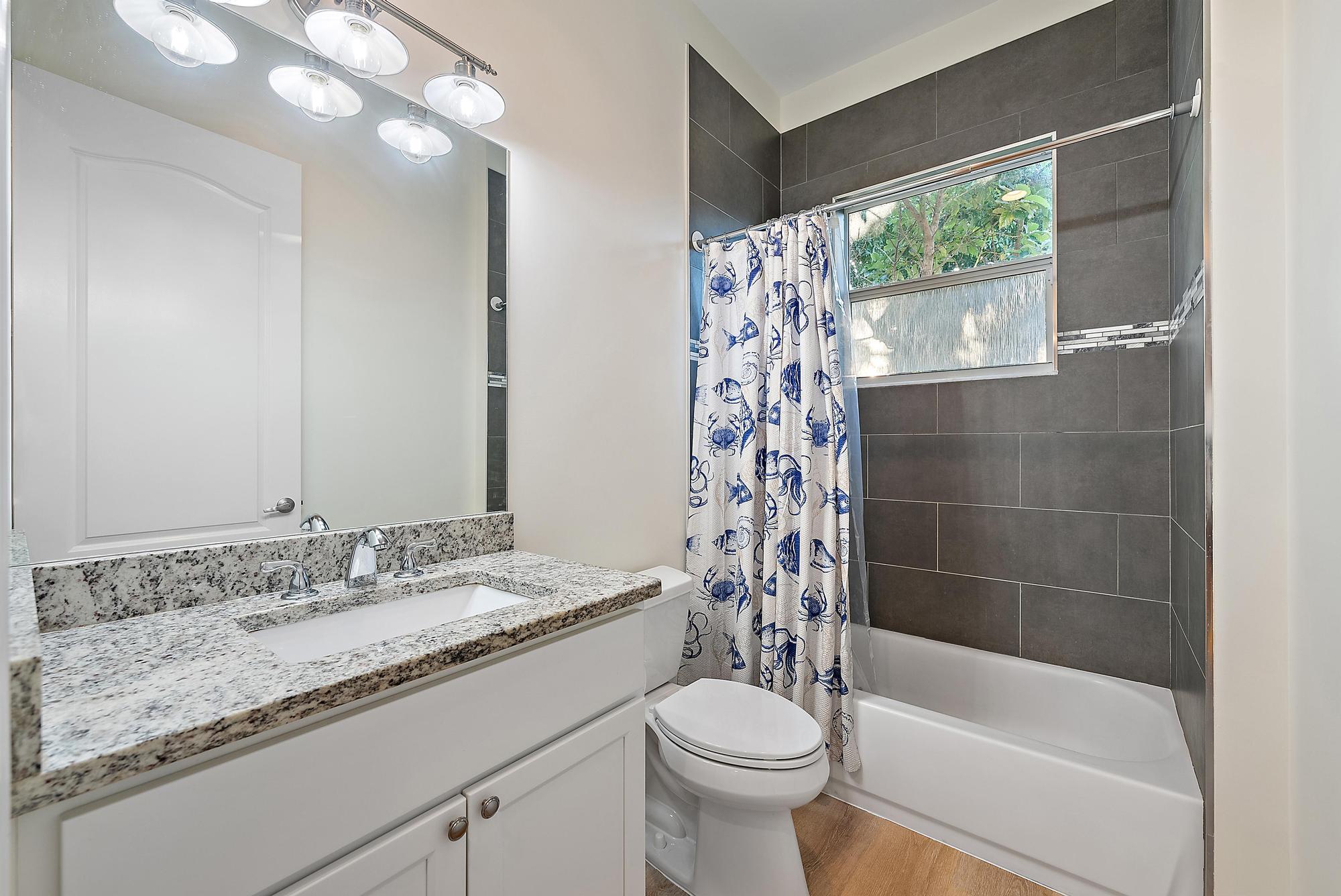 6762 2nd Street Jupiter, FL 33458 - Photo 19 of 27 a bathroom with a granite countertop sink toilet and shower