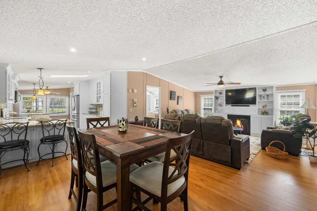 a living room with furniture a fireplace and a large window