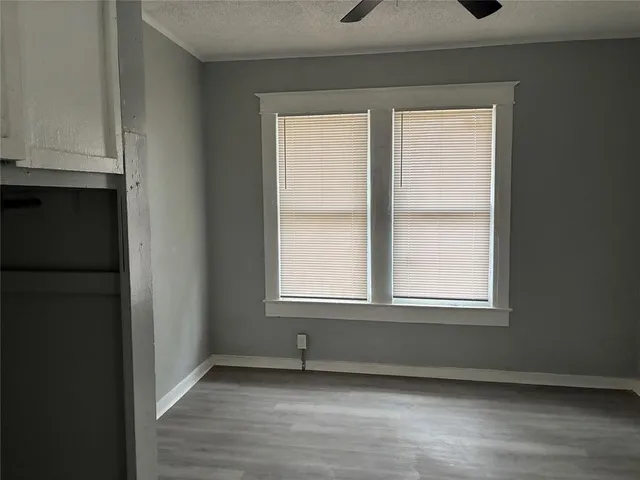 an empty room with wooden floor and windows