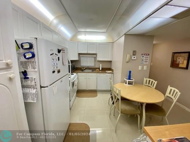 a kitchen with stainless steel appliances kitchen island a refrigerator and a dining table