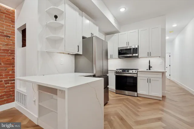 a kitchen with stainless steel appliances a stove refrigerator sink and microwave