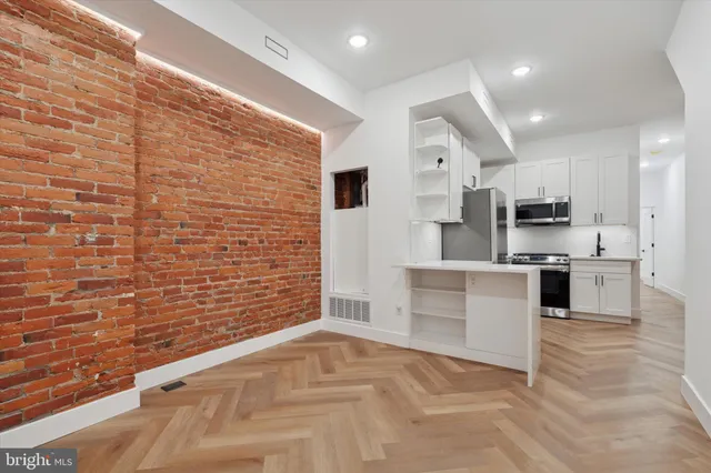 a large white kitchen with stainless steel appliances