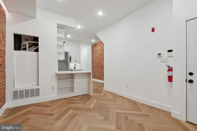 a view of a kitchen with refrigerator and white cabinets
