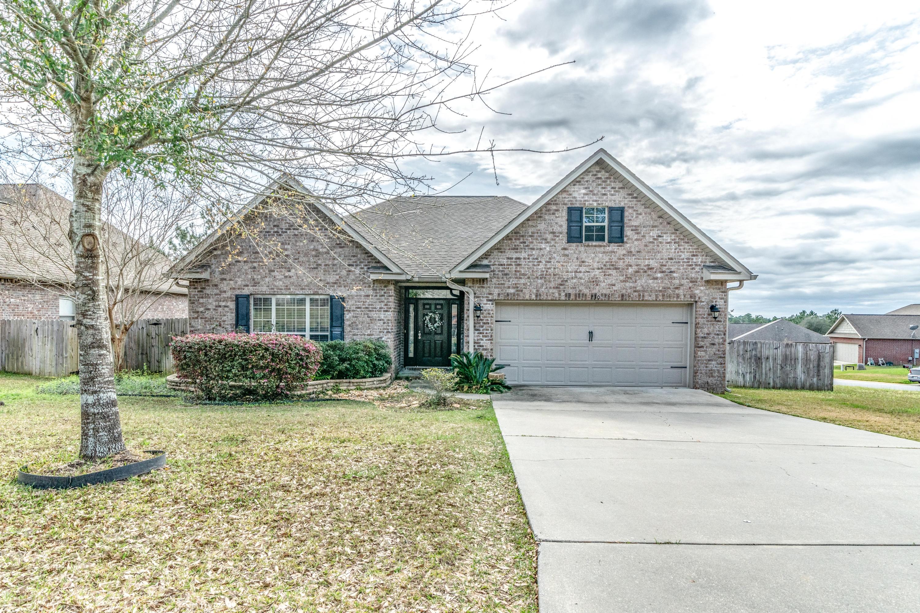 730 Lime Lane Crestview, FL 32536 - Photo 1 of 25 a front view of a house with a yard and garage