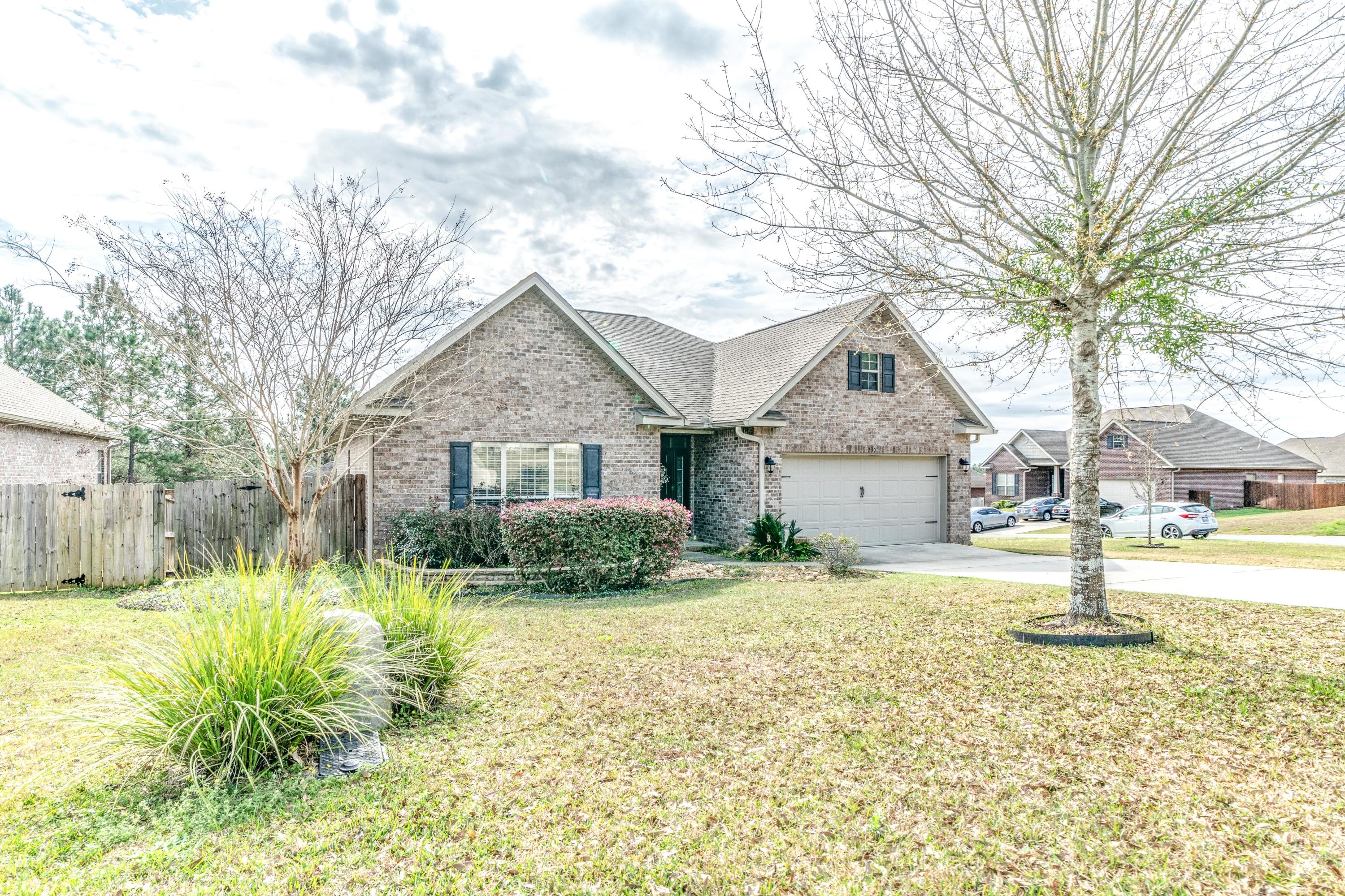 730 Lime Lane Crestview, FL 32536 - Photo 3 of 25 a front view of a house with a yard and large tree