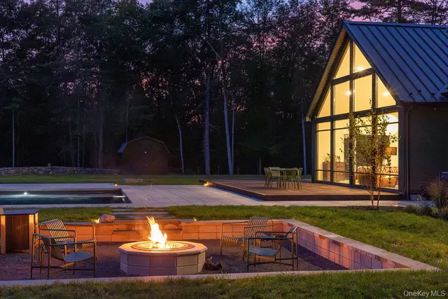 a view of swimming pool with lawn chairs and plants