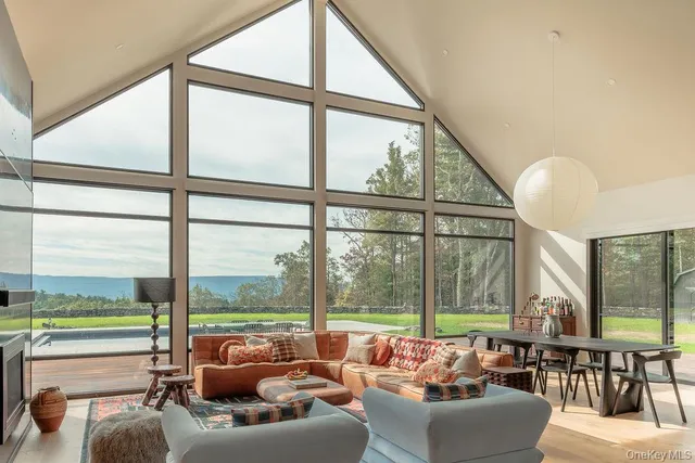 a living room with furniture and floor to ceiling windows