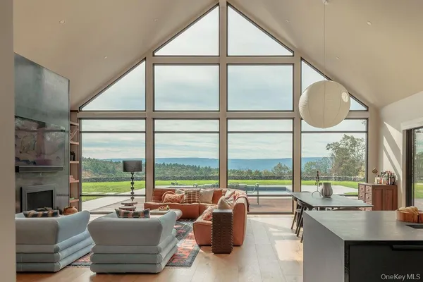a living room with furniture and floor to ceiling windows