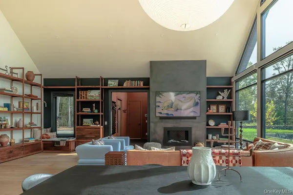 a living room with furniture a fireplace and a large window