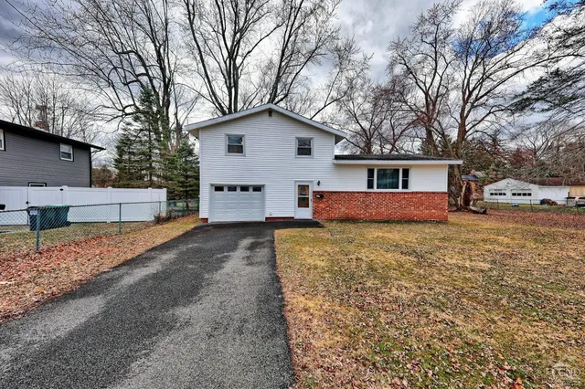 a view of house with backyard and trees
