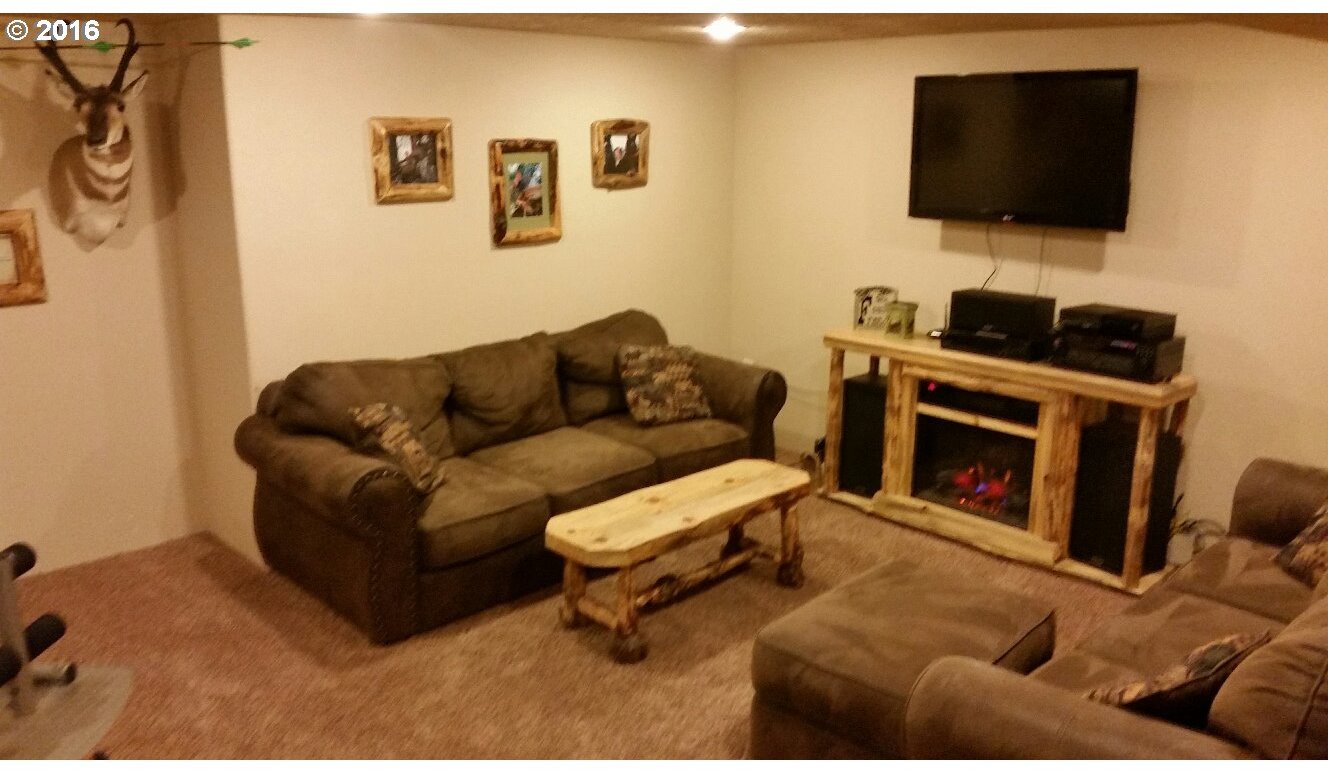 77862 North Ash Road Stanfield, OR 97875 - Photo 13 of 28 a living room with furniture a flat screen tv and a fireplace