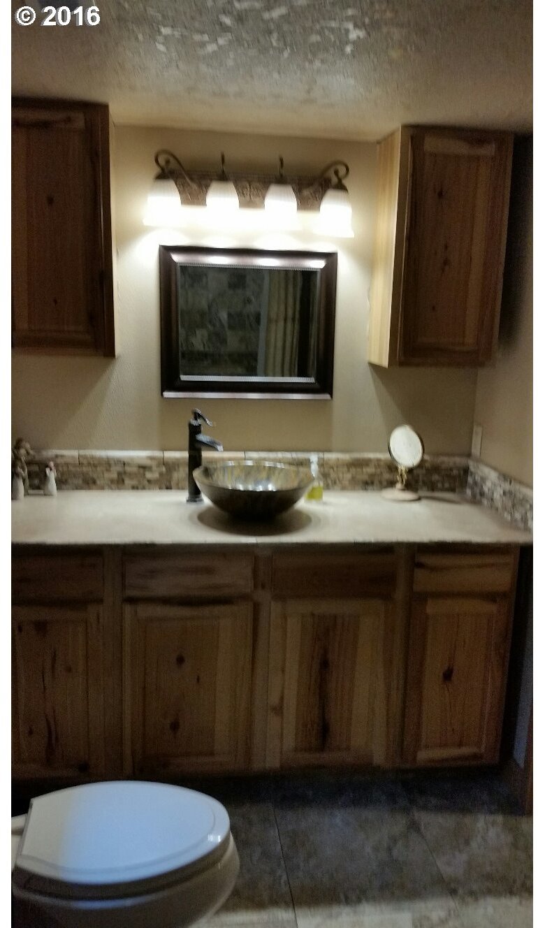 77862 North Ash Road Stanfield, OR 97875 - Photo 9 of 28 a bathroom with a granite countertop toilet sink and mirror