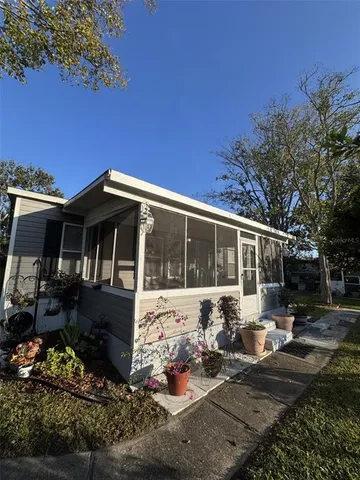 a view of a house with backyard sitting area and swimming pool