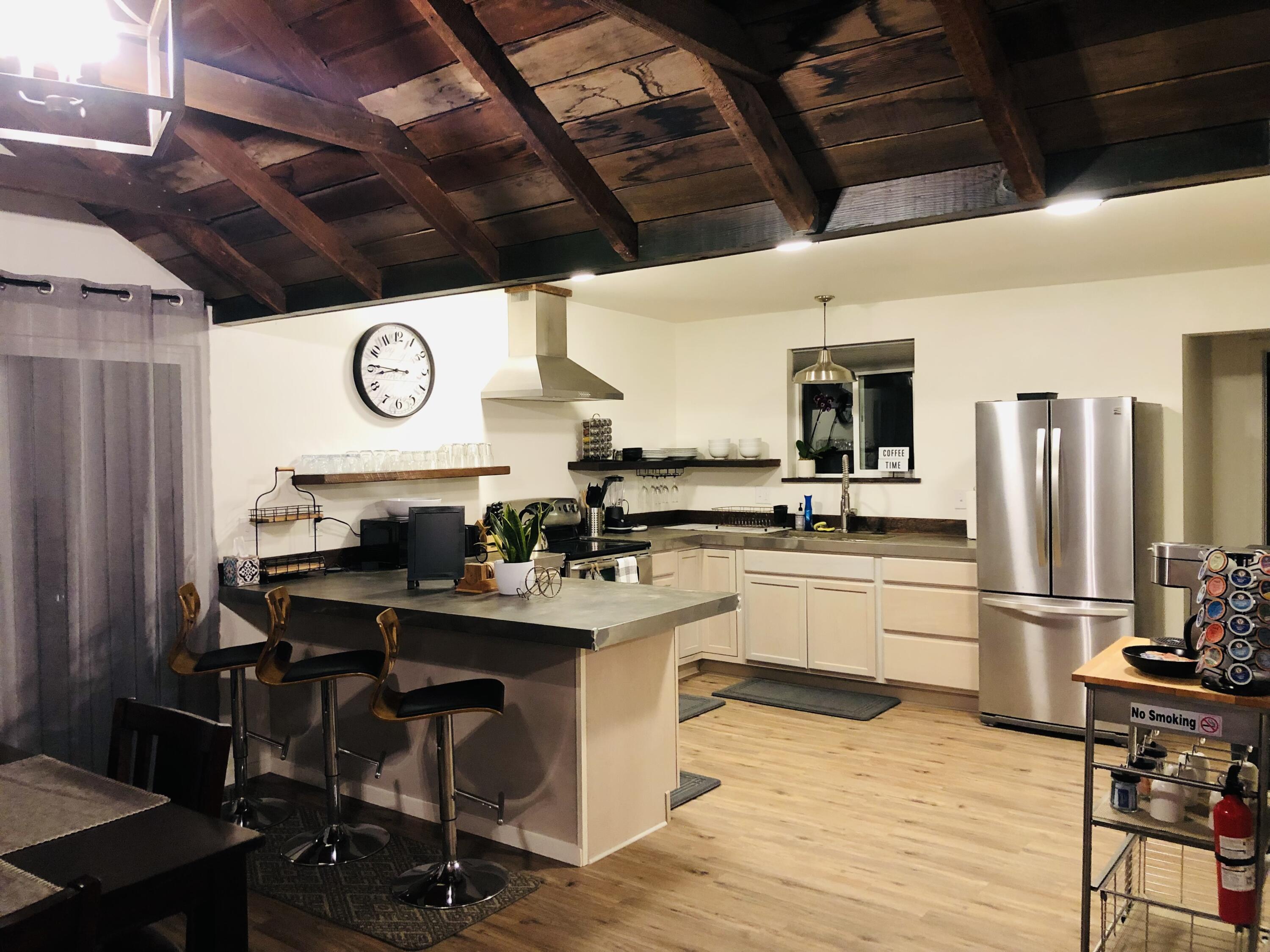 100 Den Street Los Alamos, CA 93440 - Photo 6 of 10 a kitchen with stainless steel appliances kitchen island granite countertop a table chairs stove and refrigerator