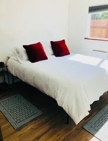 a bedroom with two beds and wooden floor
