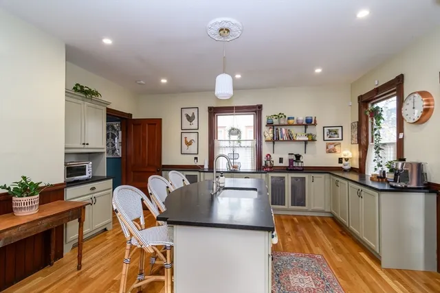 a kitchen with stainless steel appliances granite countertop sink microwave and wooden floor