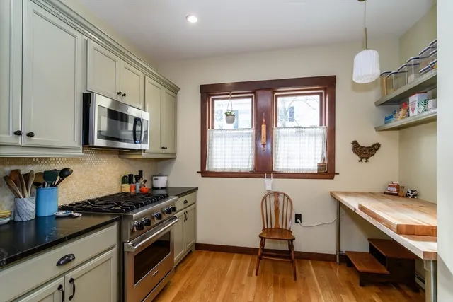 a kitchen with granite countertop wooden floors a stove and a microwave