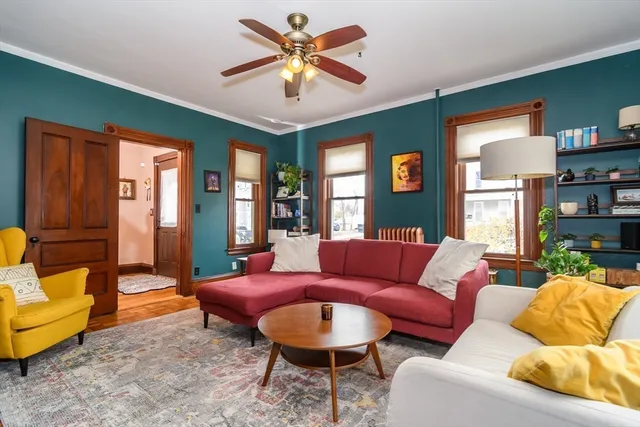 a living room with furniture a ceiling fan and a rug