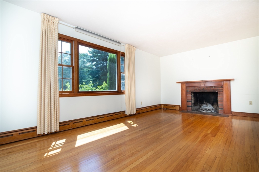 24 Ichabod Lane Marion, MA 02738 - Photo 8 of 35 an empty room with wooden floor fireplace and windows