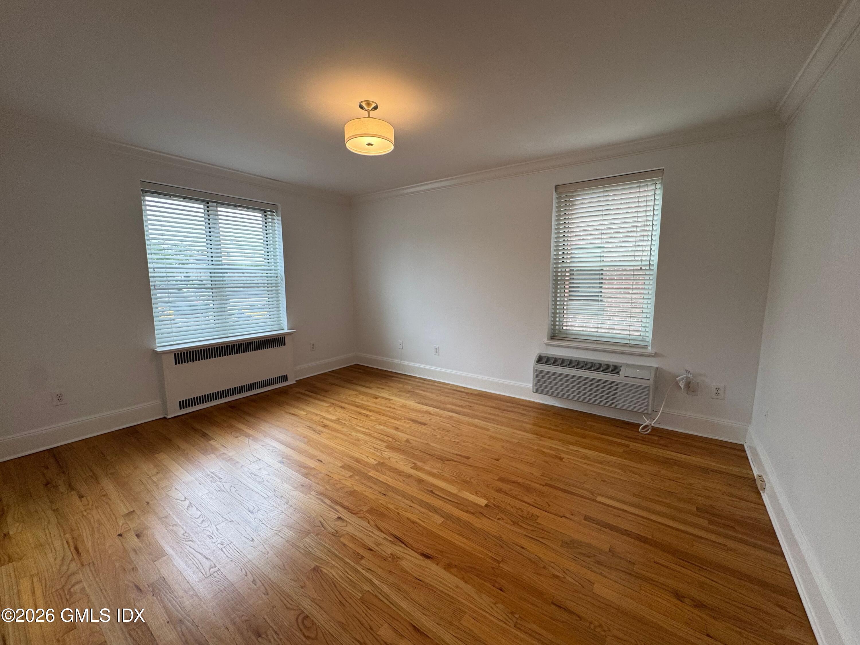 25 West Elm Street, Unit 40 Greenwich, CT 06830 - Photo 21 of 28 an empty room with wooden floor and windows