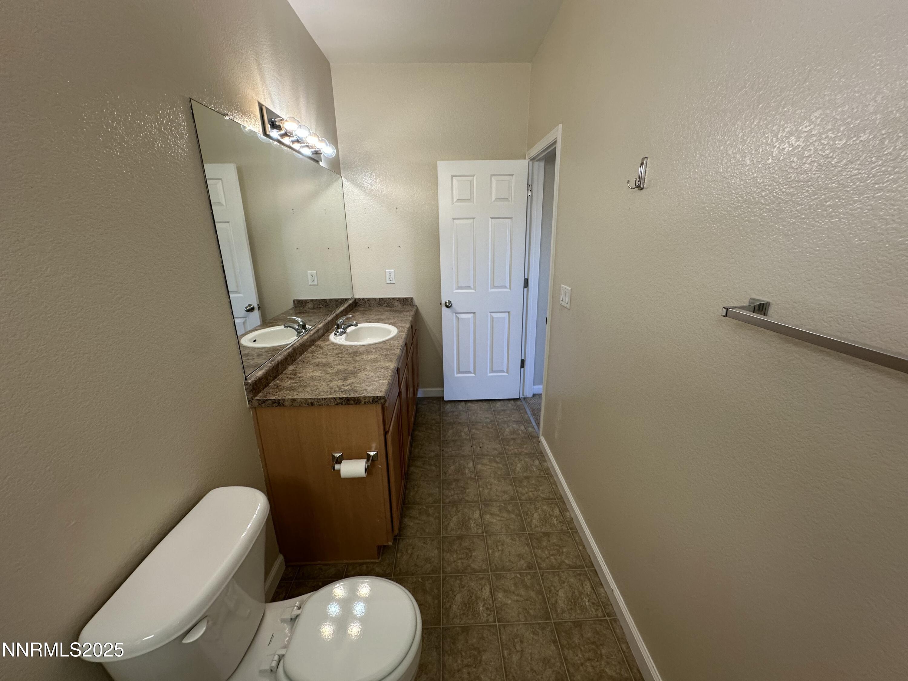 387 Orrcrest Drive Reno, NV 89506 - Photo 15 of 37 a bathroom with a granite countertop toilet sink and mirror