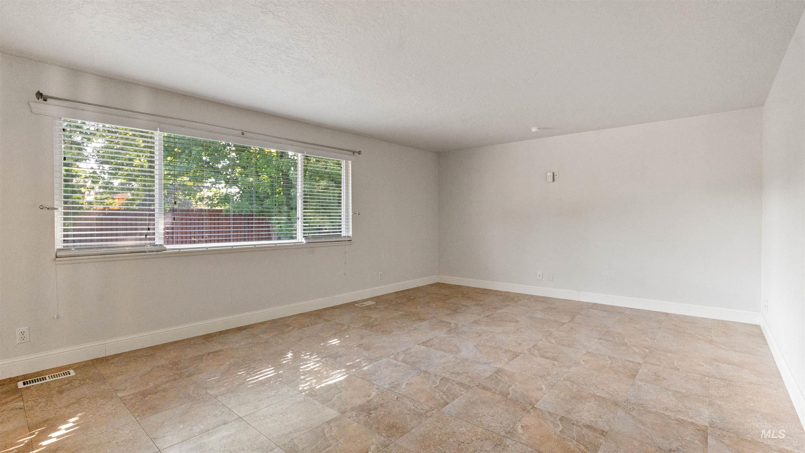 4054 North Maple Grove Road Boise, ID 83704 - Photo 26 of 34 Wood-finish flooring, white baseboards, and a single window with horizontal blinds