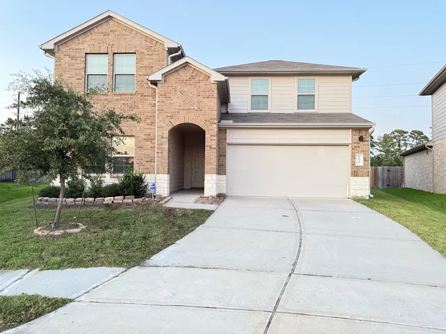 a front view of a house with a yard and garage
