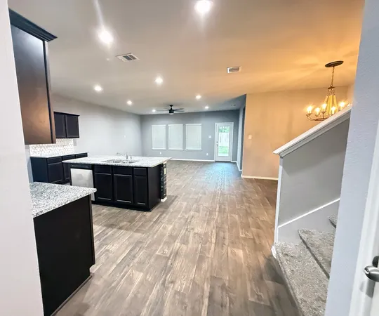 a large kitchen with stainless steel appliances kitchen island granite countertop a large counter top a stove a sink and a refrigerator