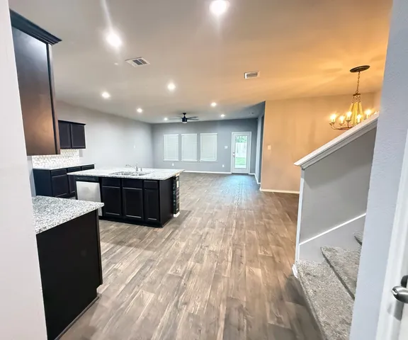 a large kitchen with stainless steel appliances kitchen island granite countertop a large counter top a stove a sink and a refrigerator