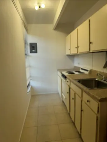 a kitchen with a sink a stove and cabinets
