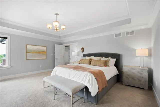 a bedroom with a bed a chandelier and a couch