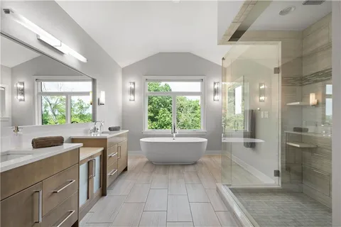 a bathroom with a granite countertop sink toilet a large mirror a bathtub and shower